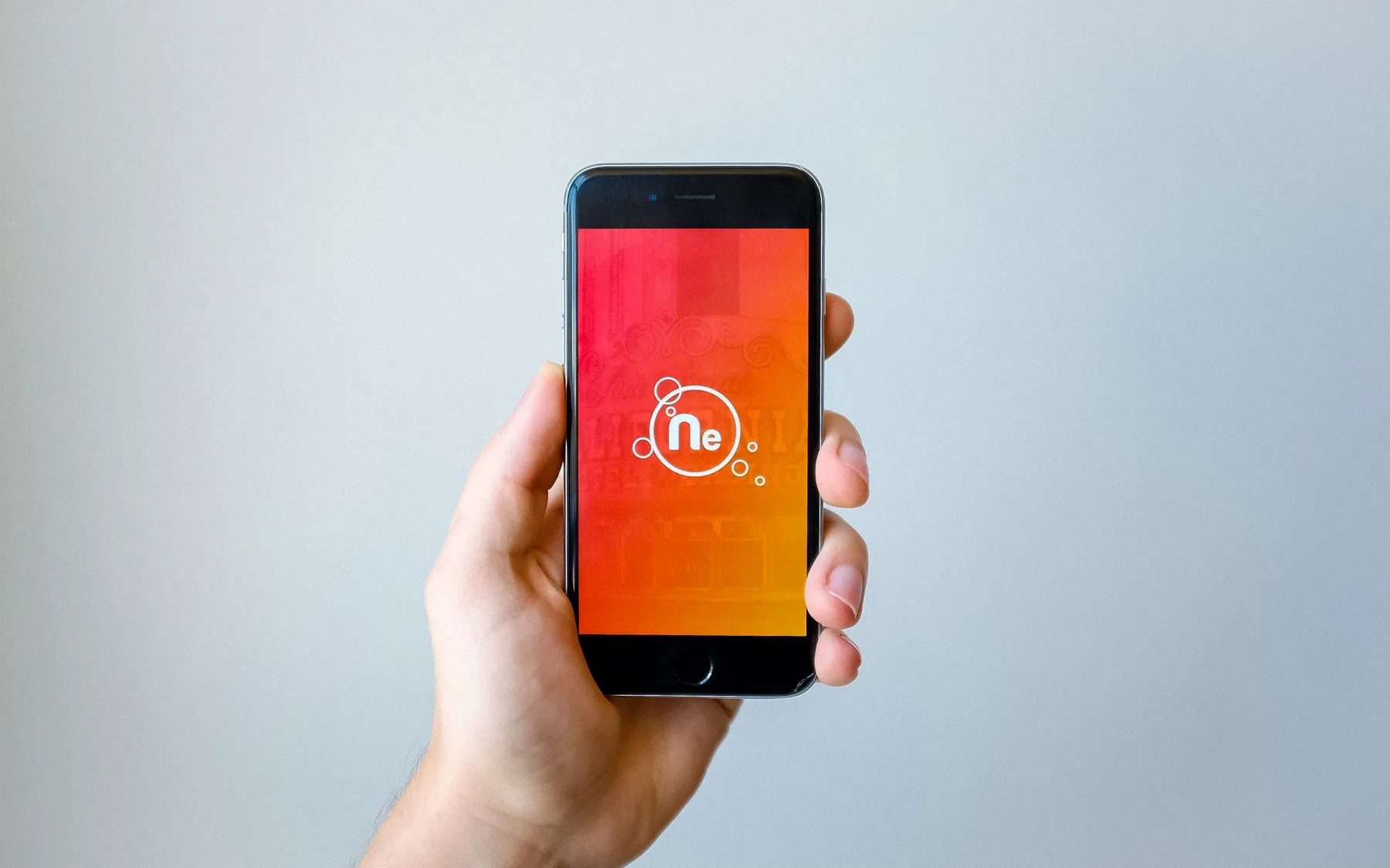 A hand holding a smartphone showing a bright app screen