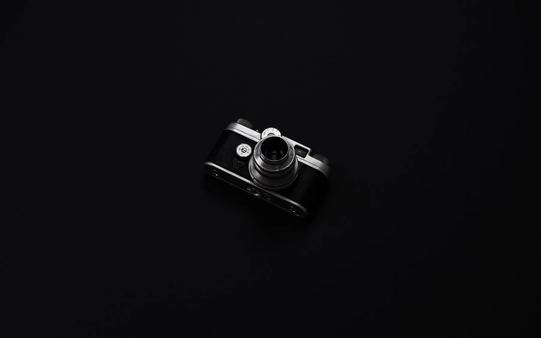 A film camera lit against a black background